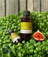 fig and olive fragrance oil. two bottles on a grassy background with a cut fig fragrance2u