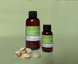 two bottles of pistachio buttercream & almond fragrance oil with five pistachios