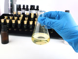 gloved hand holding flask with chemical in it