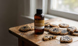 Bottle of caramelized sesame & vanilla Fragrance2U fragrance oil on a wooden board with crackers.