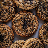 Cookies with black sesame seeds arranged on a white surface