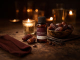 Bottle of Date Night Fragrance2U fragrance oil with dates and candles on a dark surface