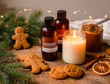 Gingerbread-themed products including a candle, cookies, and Fragrance2U Gingerbread & Cookie Butter fragrance oil bottles on a wooden surface with festive decorations.