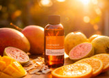 Bottle of Heatwave Fragrance2U fragrance oil surrounded by fruits on a wooden surface with a warm, blurred background.